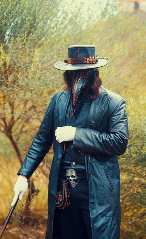 Free Plague doctor costume with mask and hat in an outdoor setting, capturing a historical and eerie vibe. Stock Photo