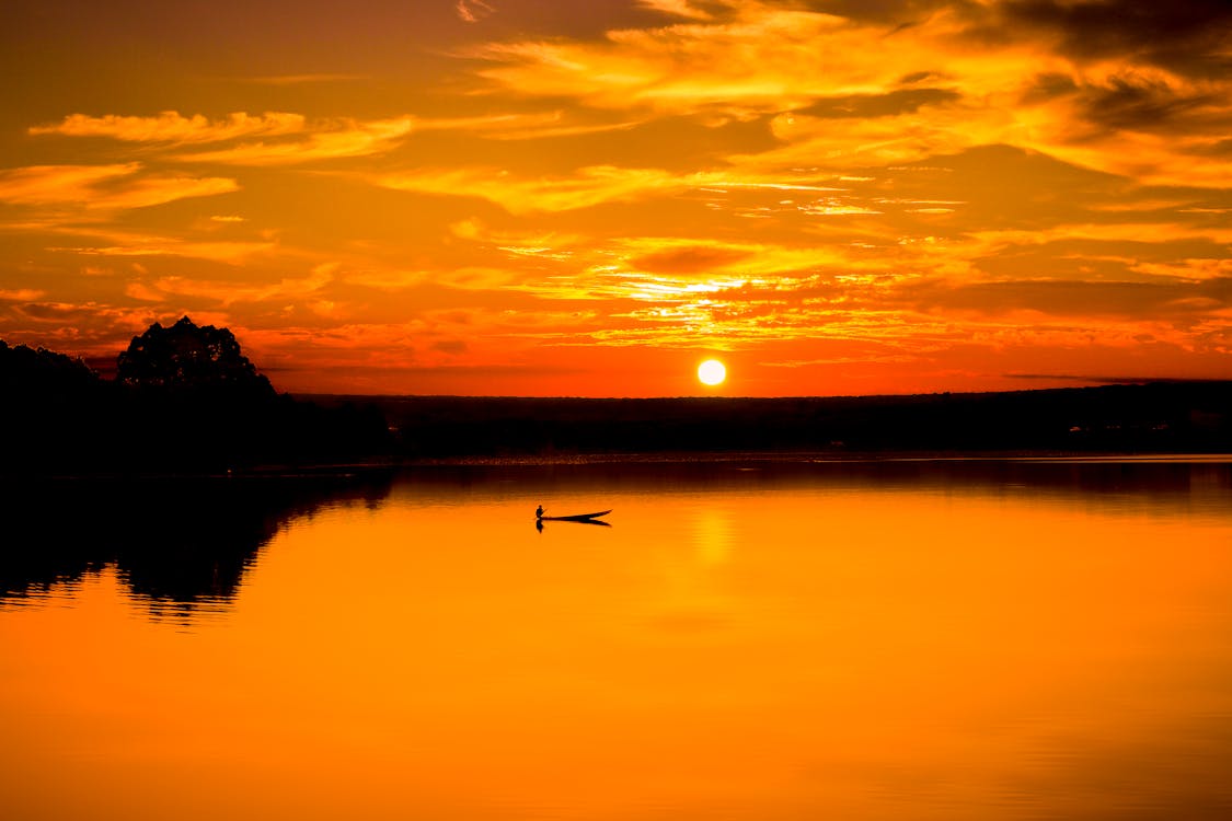 夕暮れ時の曇り空の下で明るい湖の美しい景色 無料の写真素材