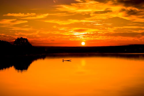 Живописный вид на яркое озеро под пасмурным небом на закате