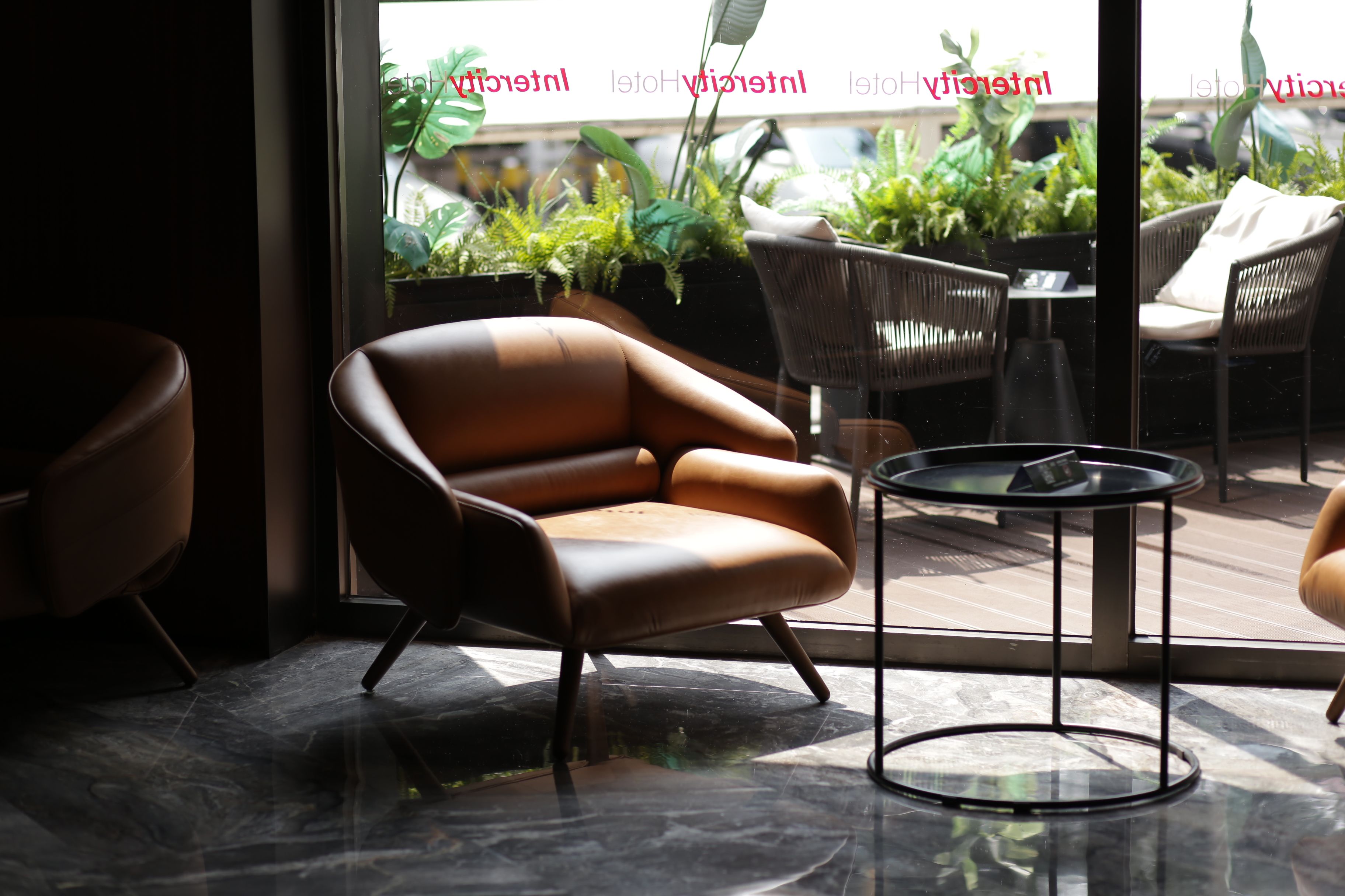 Warm guesthouse lounge with leather armchairs in soft sunlight