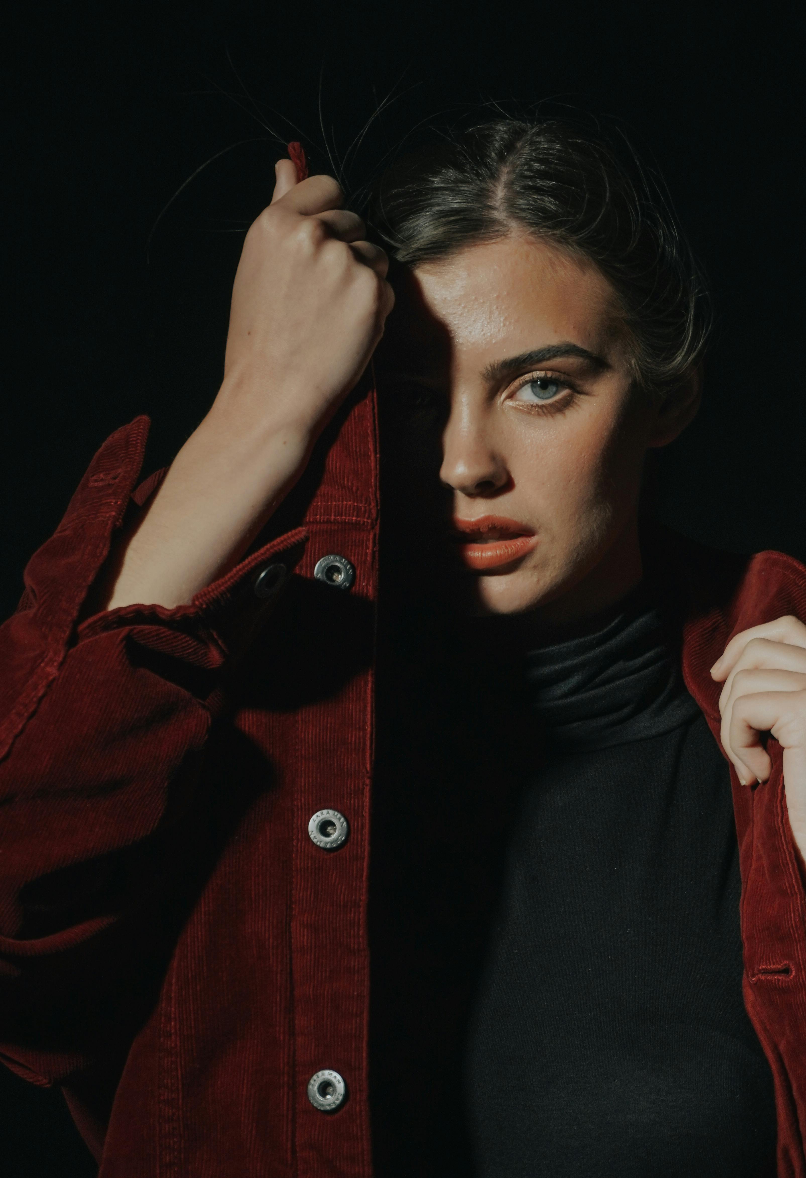 A woman wearing black shirt and red jacket. | Photo: Pexels 