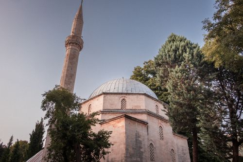 Free The Karadjoz-Bey Mosque in Mostar captured at dusk with surrounding trees. Stock Photo