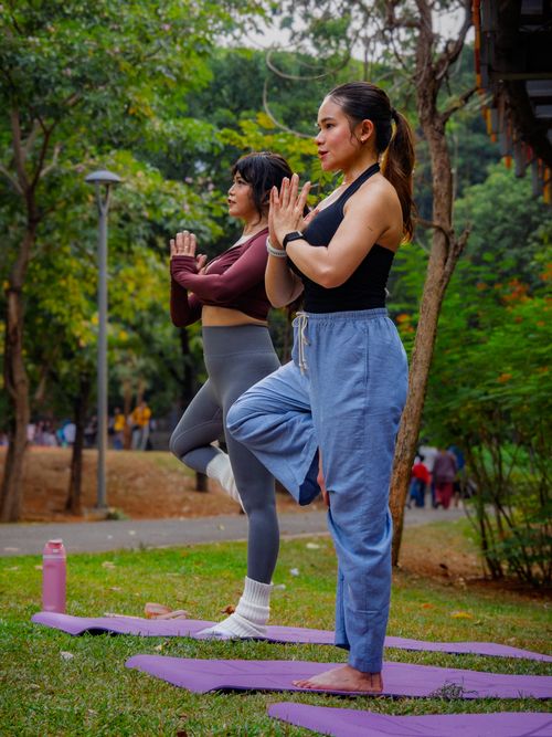Free Two women performing yoga in a park setting in Jakarta, Indonesia. Stock Photo