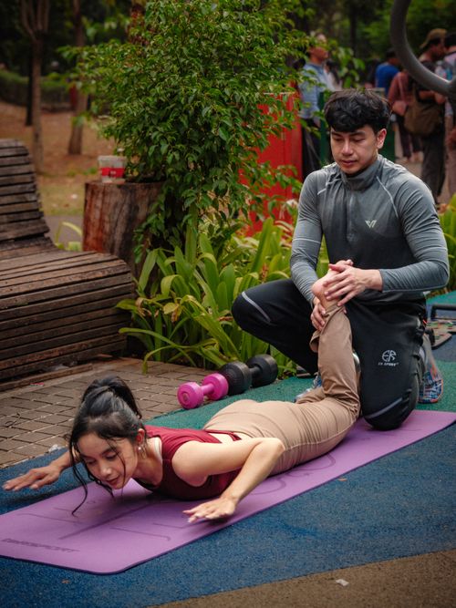 Free A woman practices yoga outdoors with an instructor's guidance in Jakarta, Indonesia. Stock Photo