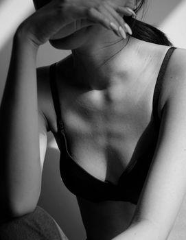 A striking black and white portrait of a woman in lingerie, showcasing elegance and mystery.
