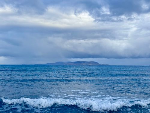 Free Peaceful view of the sea with a cloudy sky on Crete's coast, perfect for travel inspiration. Stock Photo