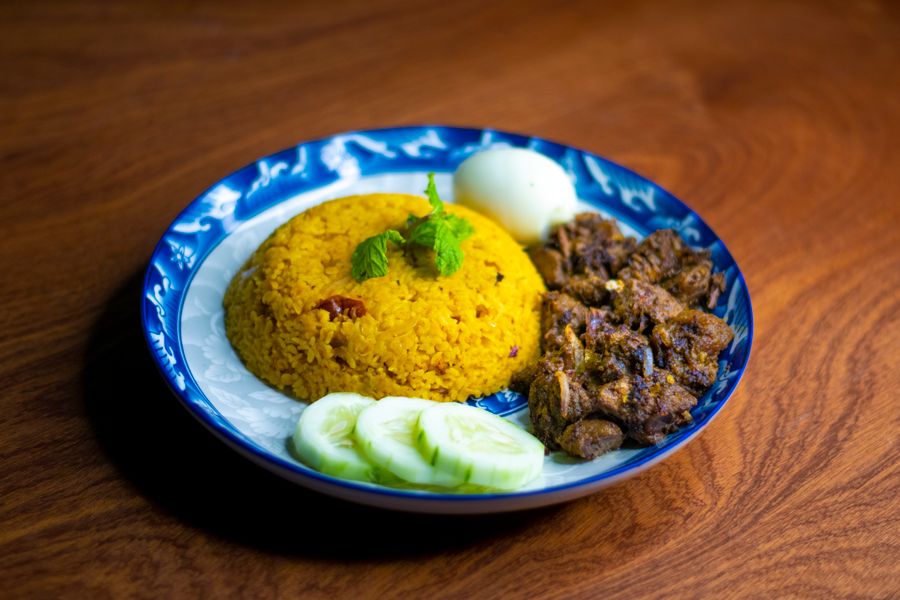 Spiced rice and grilled meat on a blue plate