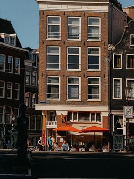 A vibrant outdoor cafe scene in Amsterdam with people enjoying a sunny day.