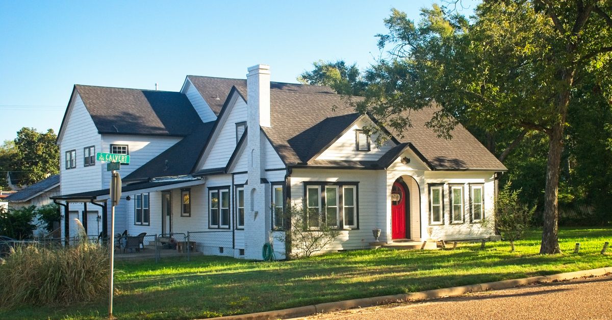 Cozy craftsman-style house with a red door on a corner lot in Troup, Texas.