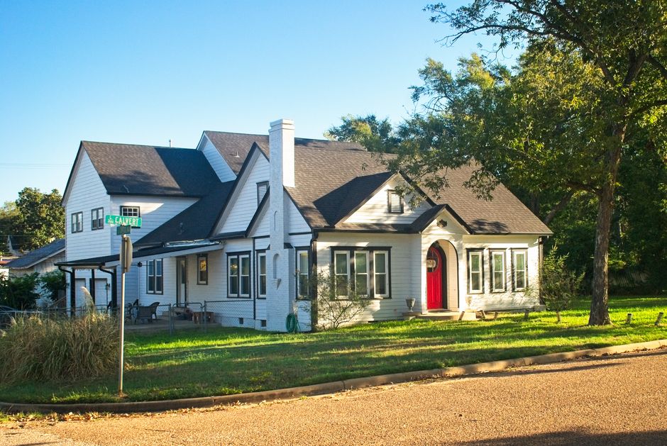 Cozy craftsman-style house with a red door on a corner lot in Troup, Texas.