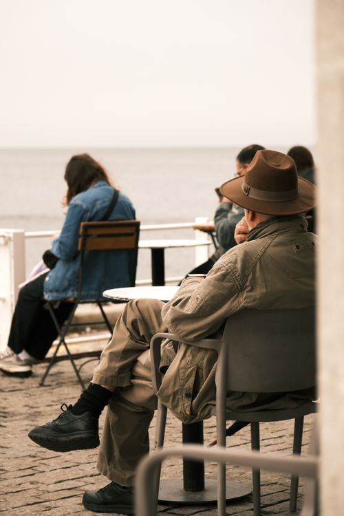 Free People enjoying a calm seaside view while seated at an outdoor cafe. Stock Photo