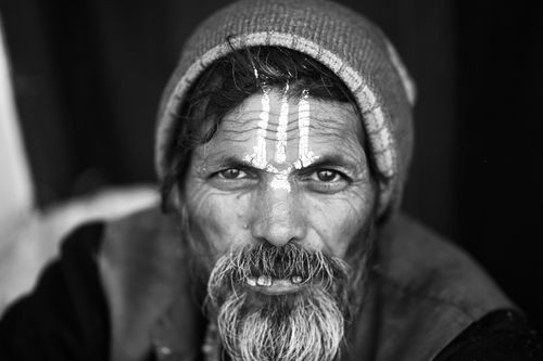 Free Expressive black and white portrait of an elderly man with traditional markings, wearing a beanie. Stock Photo