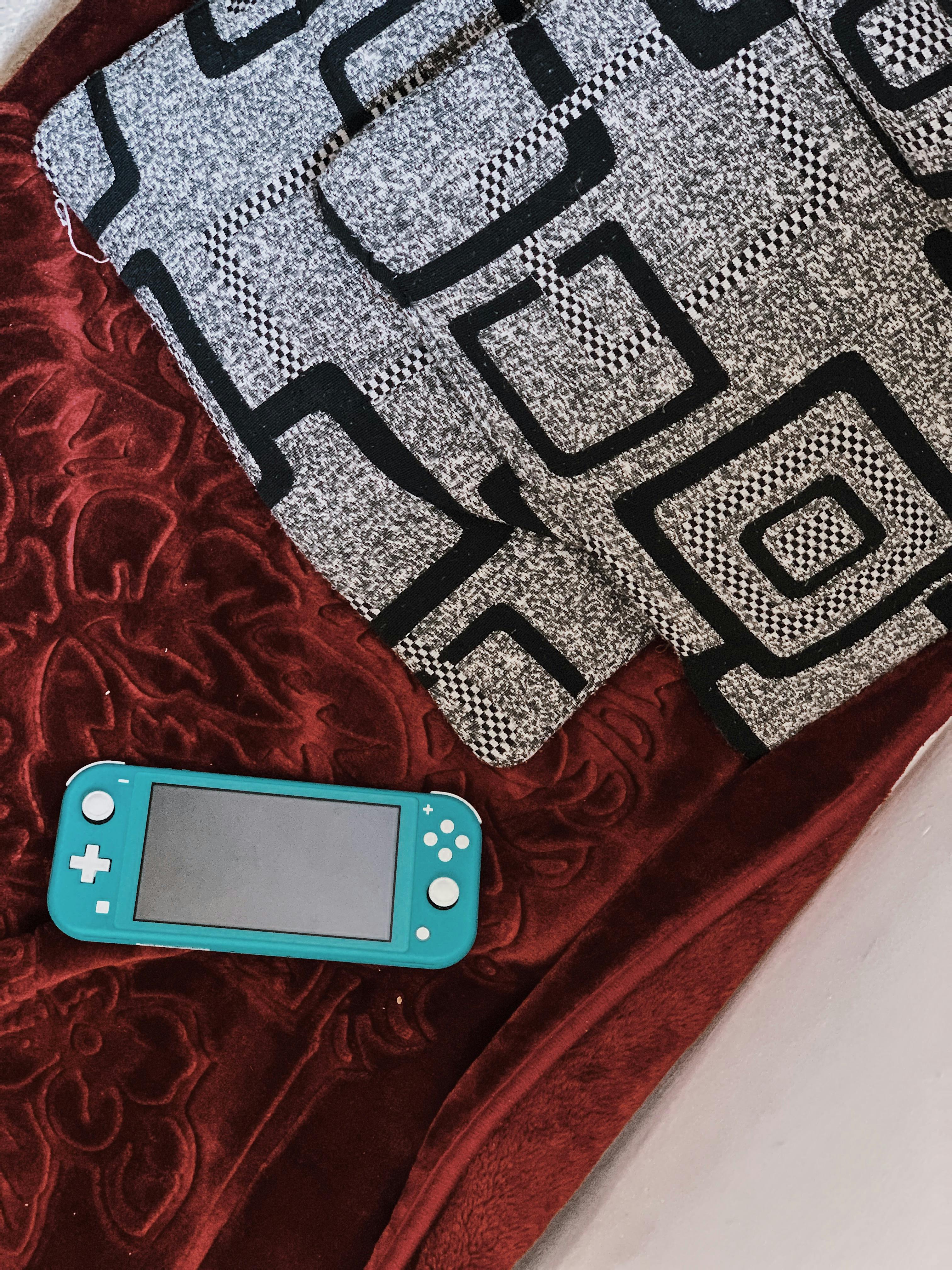 portable game pad on velour plaid on bed at home