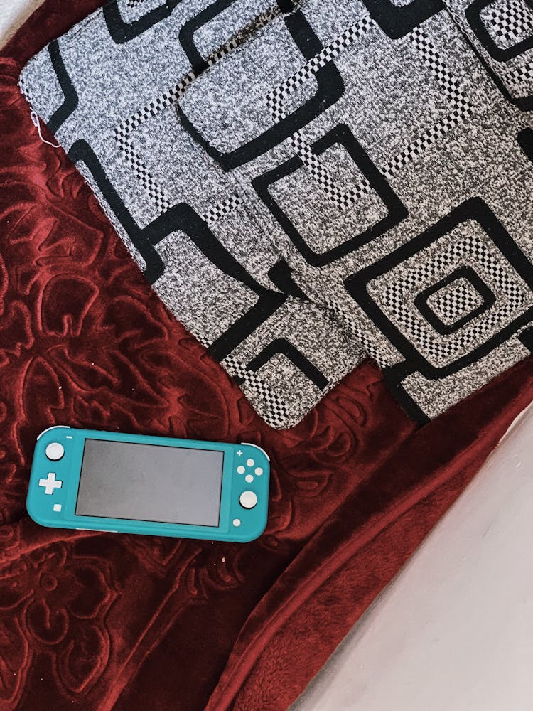 Portable Game Pad On Velour Plaid On Bed At Home