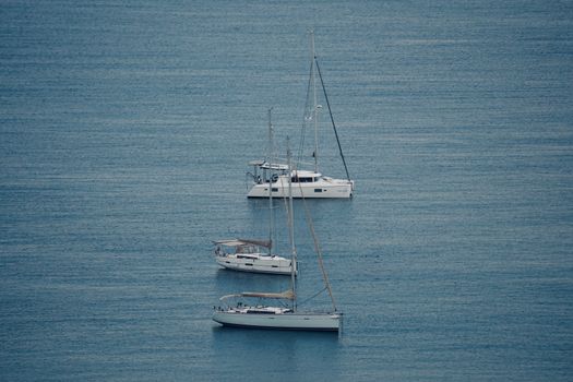 Peaceful scene of yachts floating on calm blue waters, ideal for travel and leisure concepts.