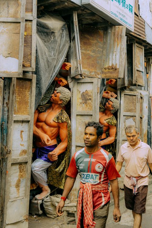 Free People walking by vibrant statues on a lively Indian street, showcasing local culture and artistry. Stock Photo