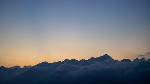 Free Captivating view of mountains silhouetted against a serene sunset sky. Stock Photo