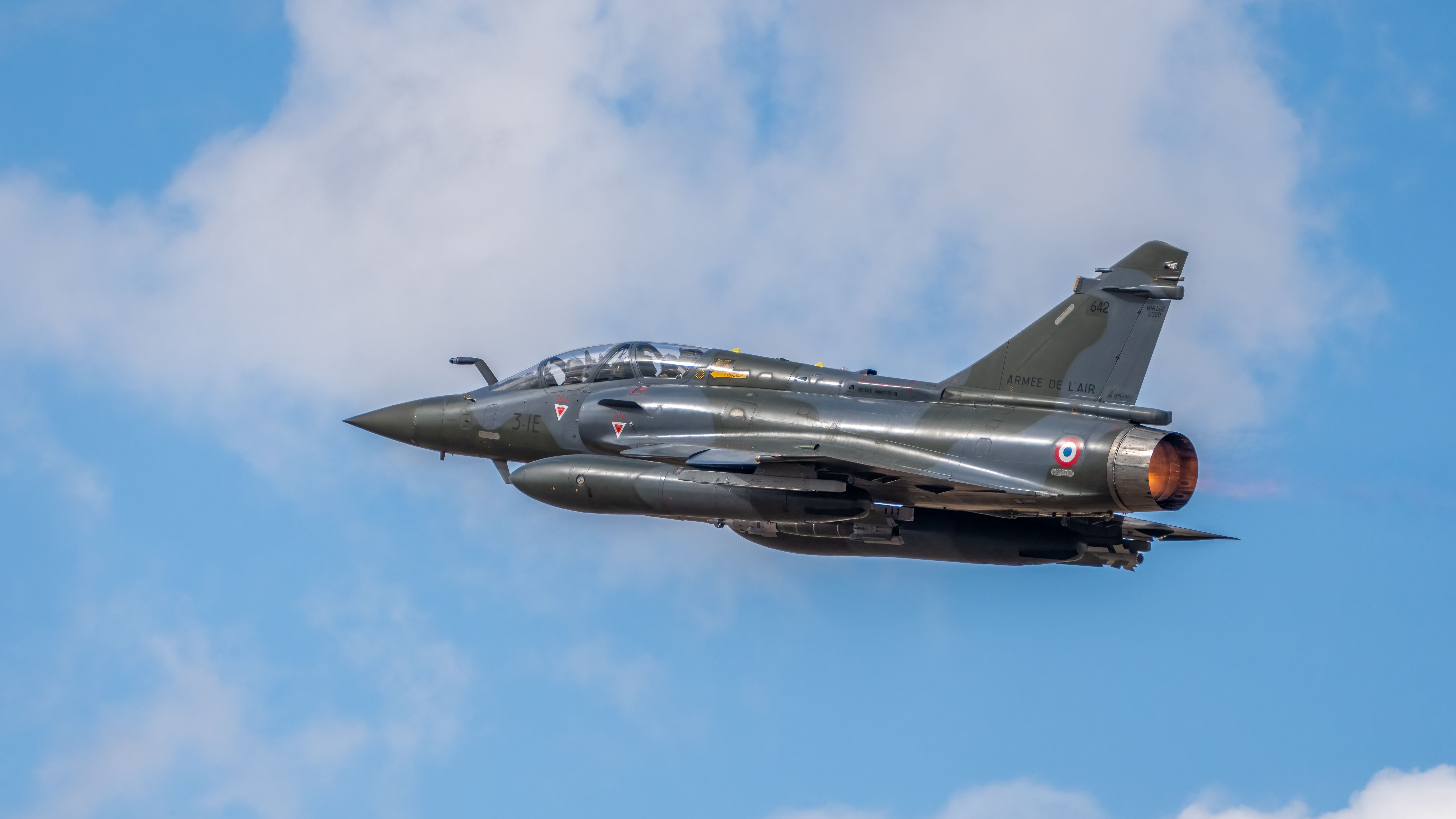 French Air Force Mirage 2000 jet soaring through a blue sky in Albacete, Spain.