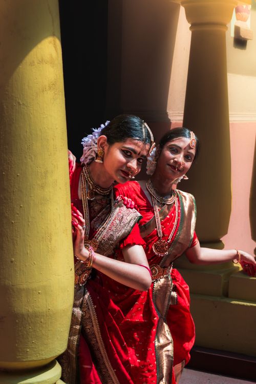 Free Two women in vibrant sarees striking a traditional dance pose in Purulia, India. Stock Photo
