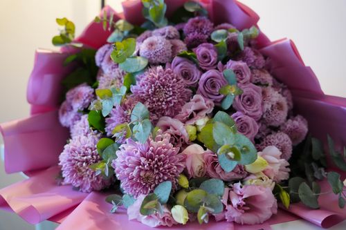 Free Beautiful pink bouquet featuring chrysanthemums and roses, elegantly wrapped in a pastel pink paper. Stock Photo