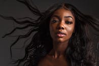 迷人的肖像描绘了一位拥有飘逸头发和充满活力的眼睛的女性，捕捉到了美丽和自信