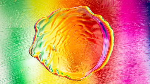 Free Colorful close-up of a swirling liquid pattern with a rainbow palette. Stock Photo