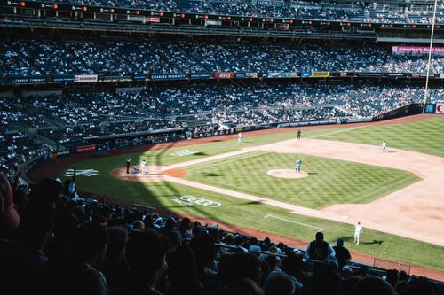 Free An aerial view of a baseball game in a fully packed stadium during the day, showing players on the field. Stock Photo