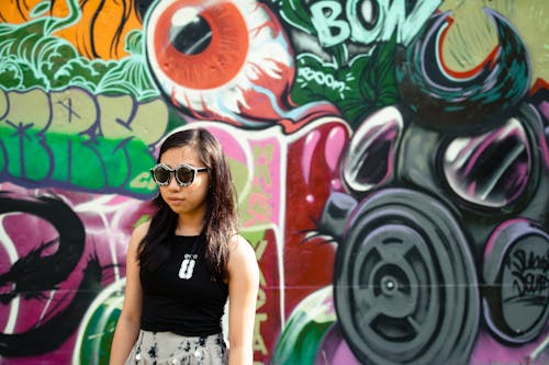Kobieta W Czarnych Górnych I Czarnych Okulary Przeciwsłonecznych Stojących Obok ściany Graffiti
