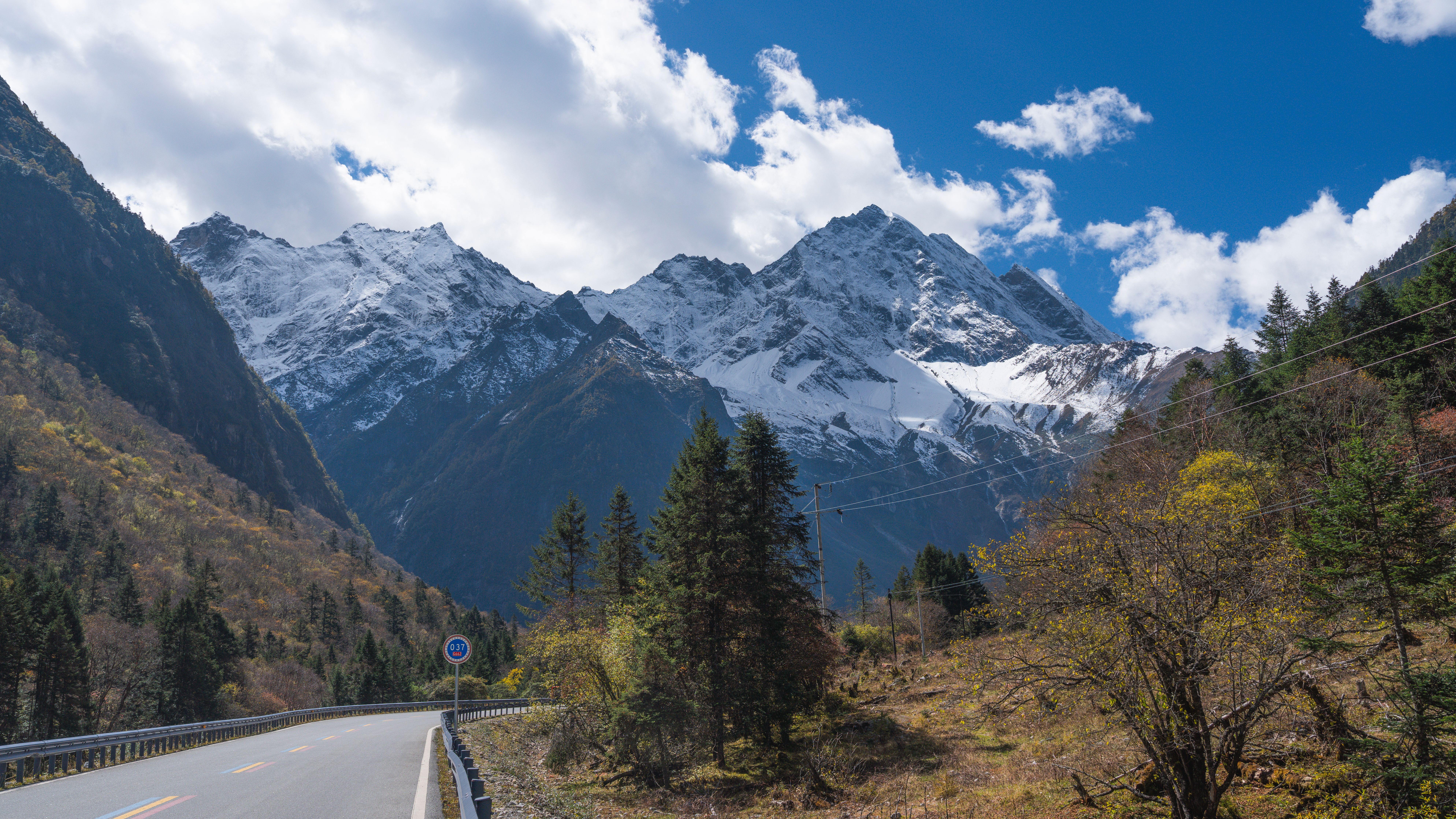Fotomural Impresionante paisaje de la montaña Siguniang con picos nevados y un cielo azul despejado.