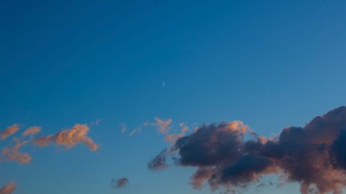 Free A serene sky with a crescent moon and clouds at twilight, capturing a peaceful atmospheric scene. Stock Photo
