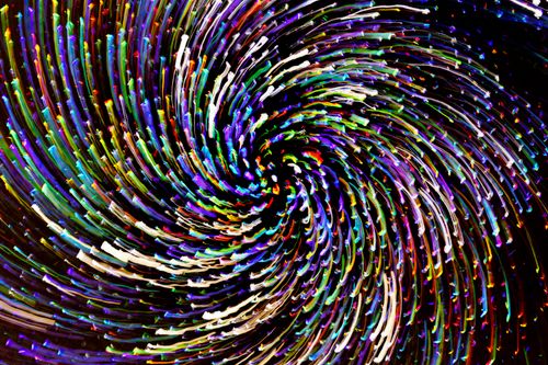 Free A dynamic and colorful spiral pattern created with long-exposure light photography. Stock Photo