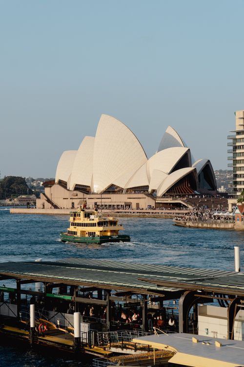 Free Iconic Sydney Opera House with a ferry in the foreground on a clear day. Stock Photo