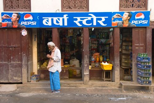 Free Elderly man stands in front of a local store with Pepsi signage in urban India. Stock Photo