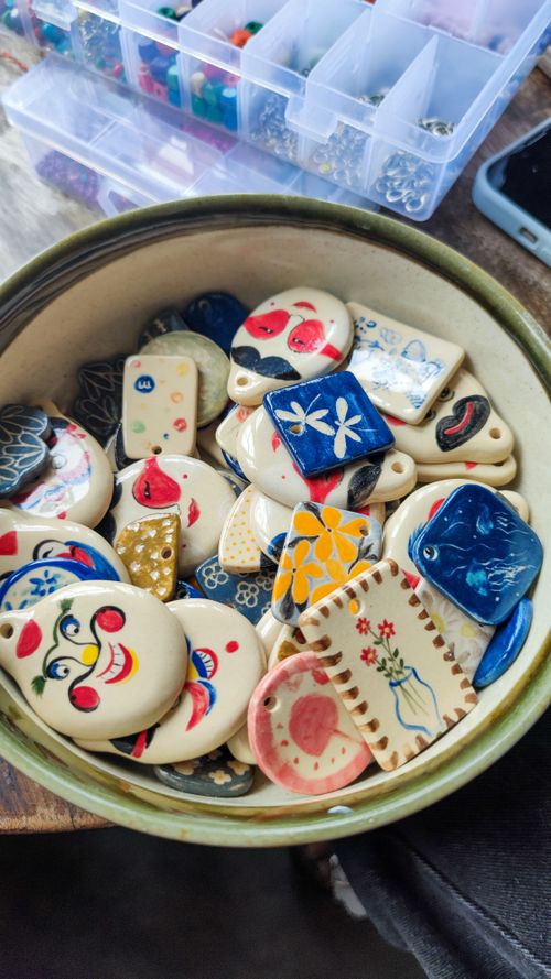 Free Vibrant handmade ceramic charms showcase traditional Vietnamese artistry in a rustic bowl. Stock Photo