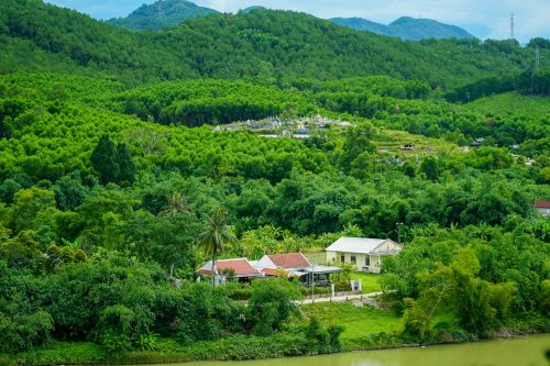 Free Peaceful rural landscape in Hue, Vietnam with lush greenery, forests, and traditional houses. Stock Photo