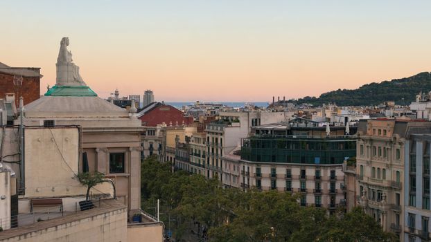 Aerial view of Barcelona's Eixample district with a pastel sky at sunset.