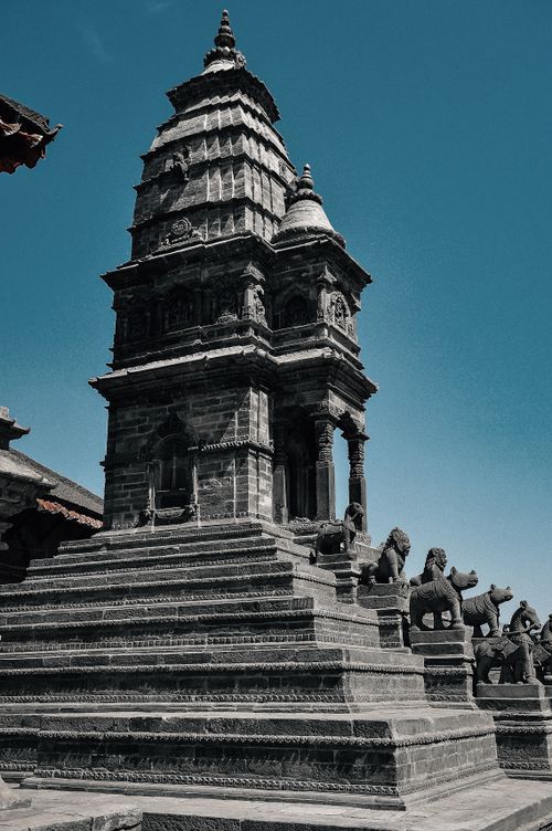 Free From below of aged masonry church facade with stairs and statues of animals under cloudless sky in daylight in Bhaktapur Stock Photo