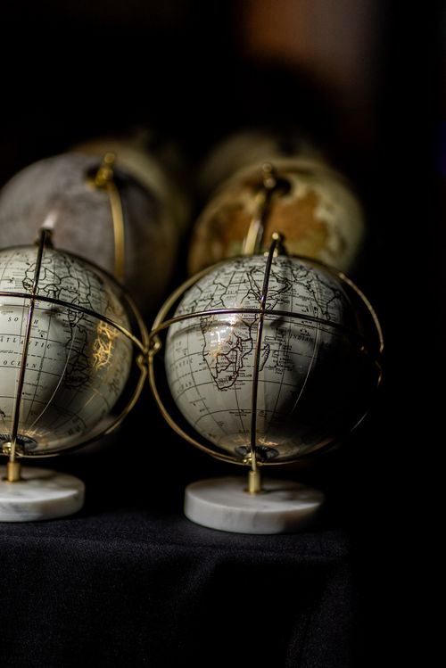 Free Close-up of vintage globes on stands in a dimly lit setting. Stock Photo