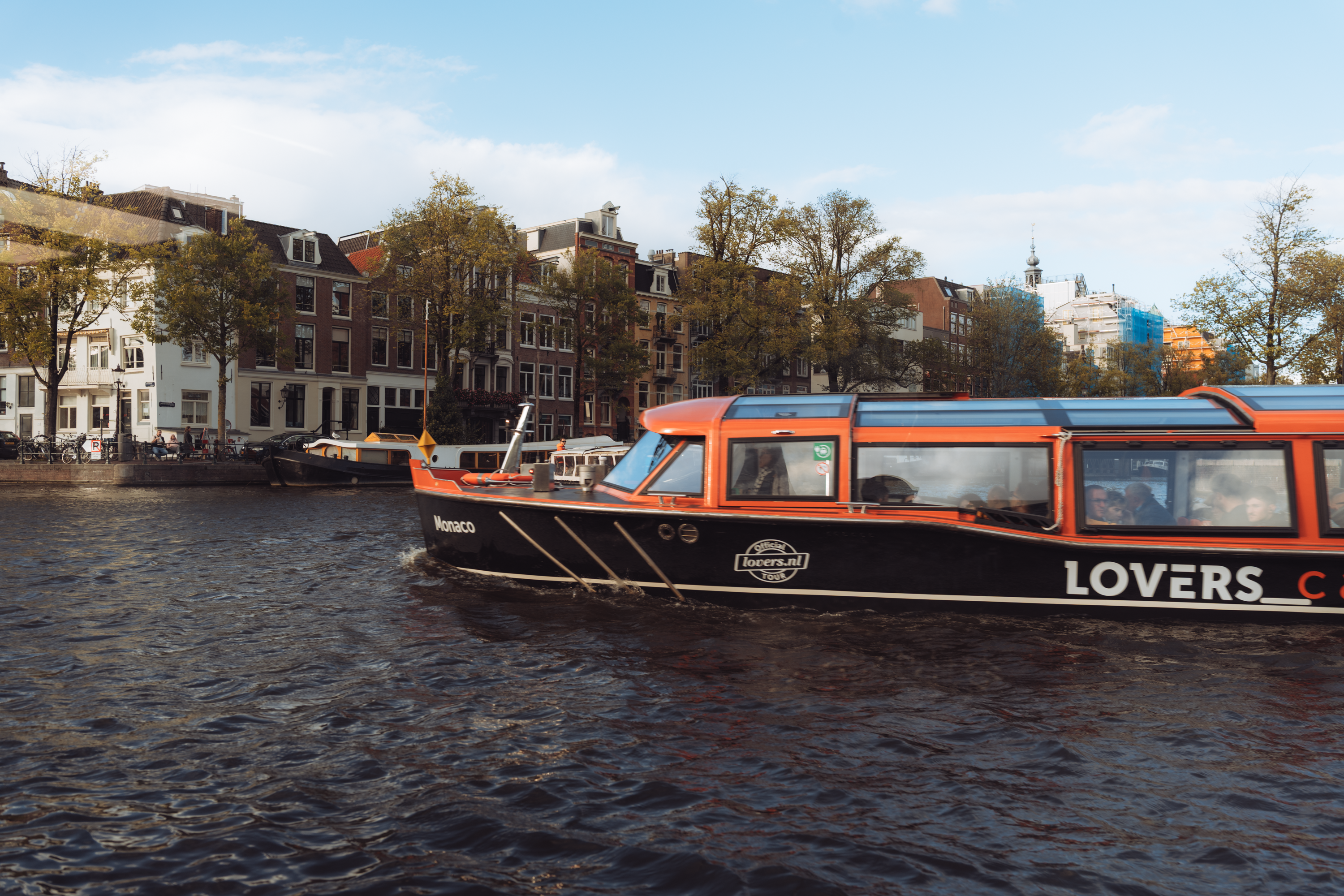 Explore the picturesque canals of Amsterdam with iconic architecture and vibrant tour boats.