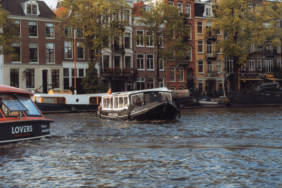 Explore Amsterdam's picturesque canals, showcasing boats and historic houses along a vibrant waterfront.