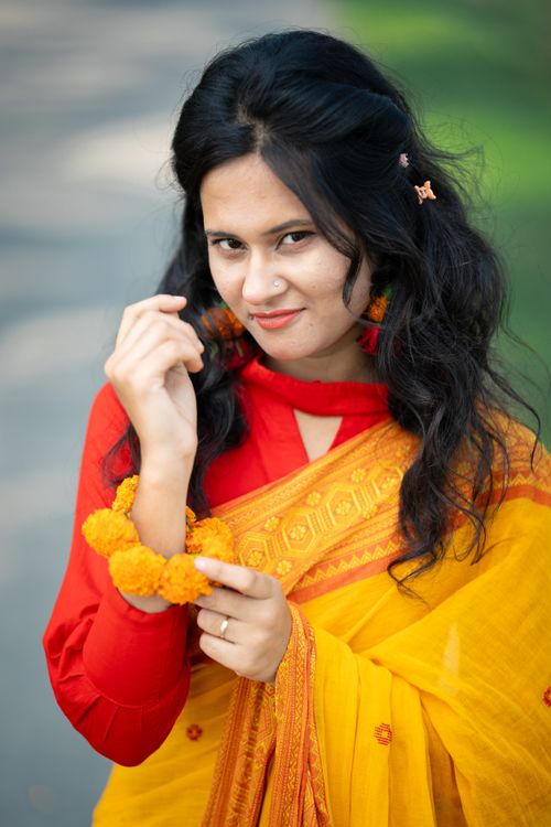 Free Beautiful South Asian woman in yellow saree, embracing cultural fashion in an outdoor setting. Stock Photo