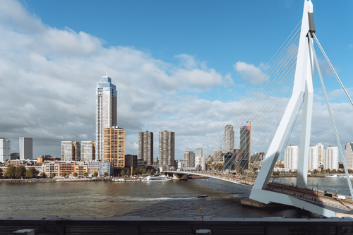 Free Experience the urban landscape of Rotterdam with the modern Erasmus Bridge and skyline under a bright sky. Stock Photo
