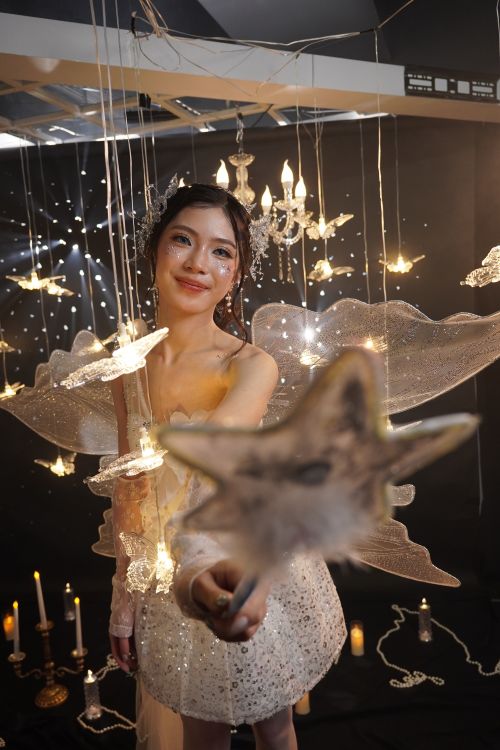 Free A woman in a fairy costume amidst glowing stars and lights, creating a magical atmosphere. Stock Photo