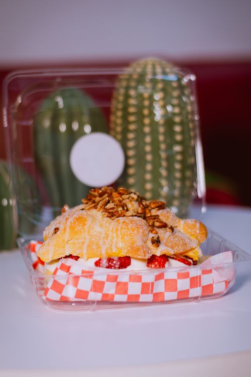 Free Delicious dessert with pecans and strawberries in a plastic container, featuring Mexican decor. Stock Photo