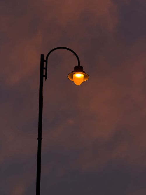 Free A glowing street lamp stands against a dramatic twilight sky in Dublin, Ireland. Stock Photo