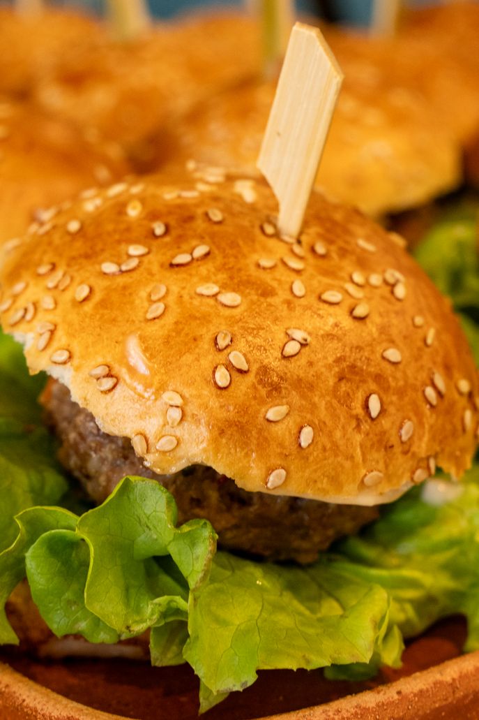 Delicious mini hamburgers with lettuce on a platter. Perfect for parties or casual dining.