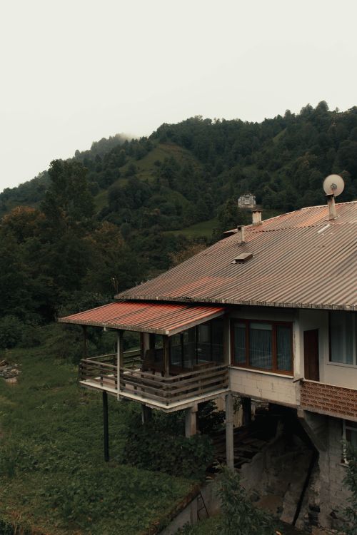 Free Rustic house in lush mountainous landscape, ideal for nature and travel themes. Stock Photo