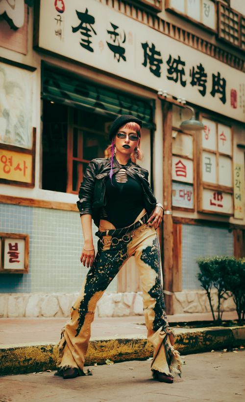 Free Fashionable woman poses confidently in a vibrant Asian urban street scene. Stock Photo