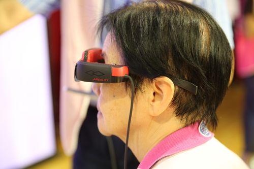 Free Adult engaged with virtual reality headset indoors at a technology event. Stock Photo
