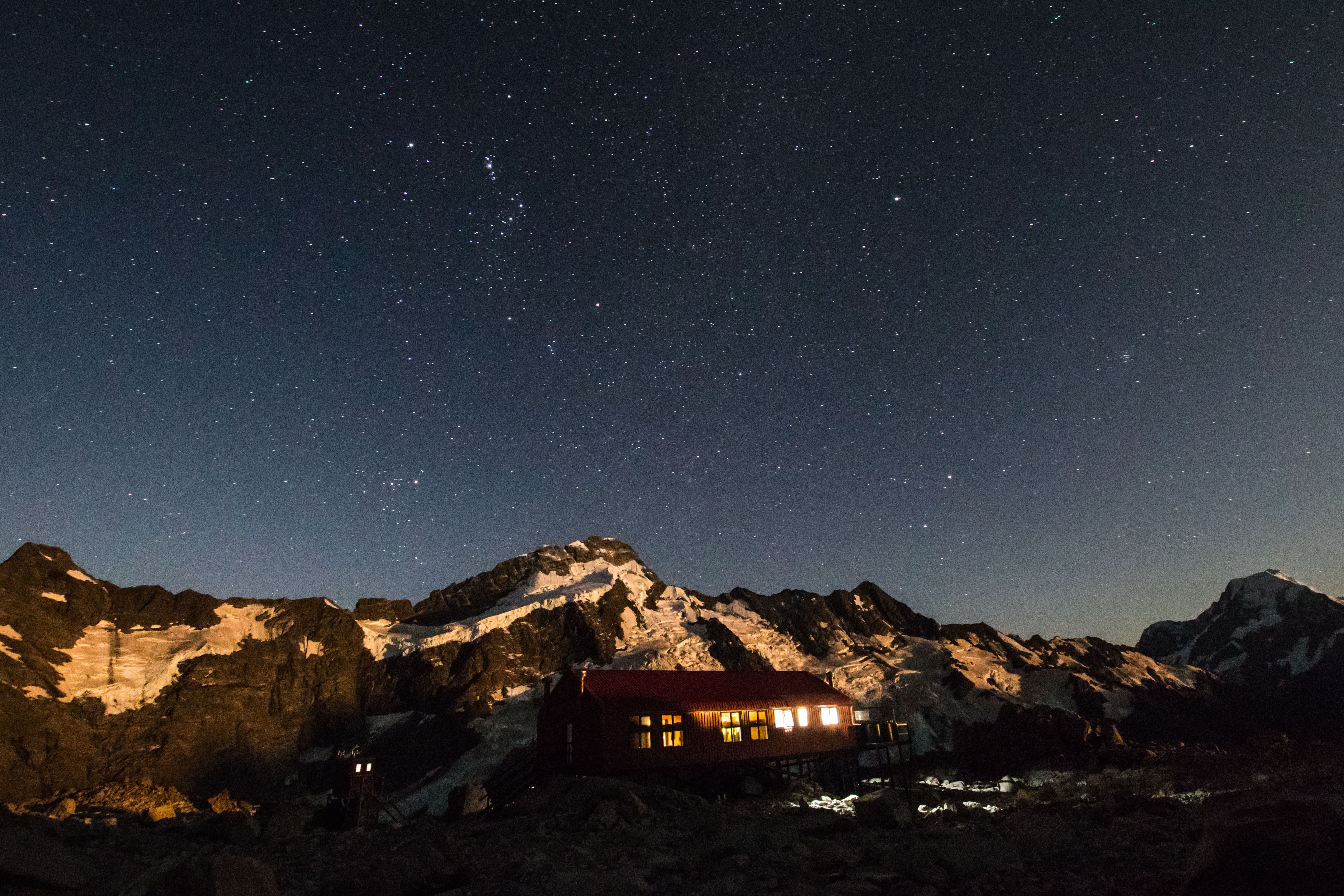 在新西兰库克山国家公园，山间小屋明亮，星空璀璨